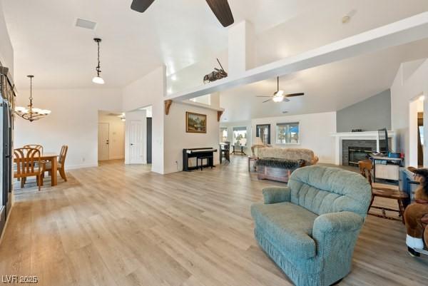 1251 Cavalry St, Pahrump, NV 89048 - living area with a ceiling fan, a fireplace, light wood-style flooring, and high vaulted ceiling
