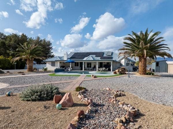 1251 Cavalry St, Pahrump, NV 89048 - rear view of property featuring roof mounted solar panels, a pool, and a patio area