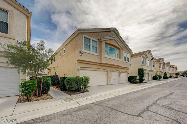 8801 Duncan Barrel Ave Unit 103, Las Vegas, NV 89178 - view of front of home with stucco siding, a garage, a residential view, and driveway