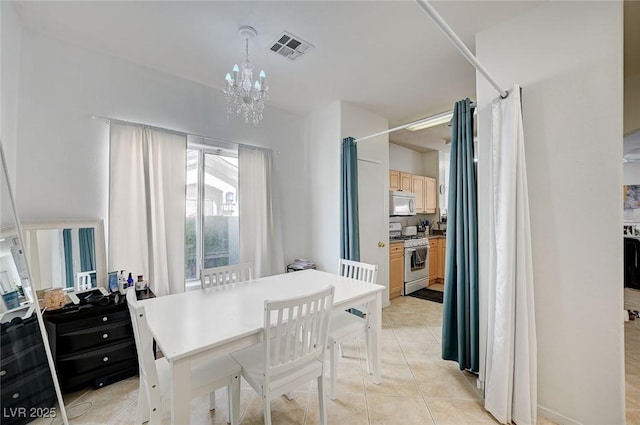dining area featuring a chandelier and light tile patterned flooring