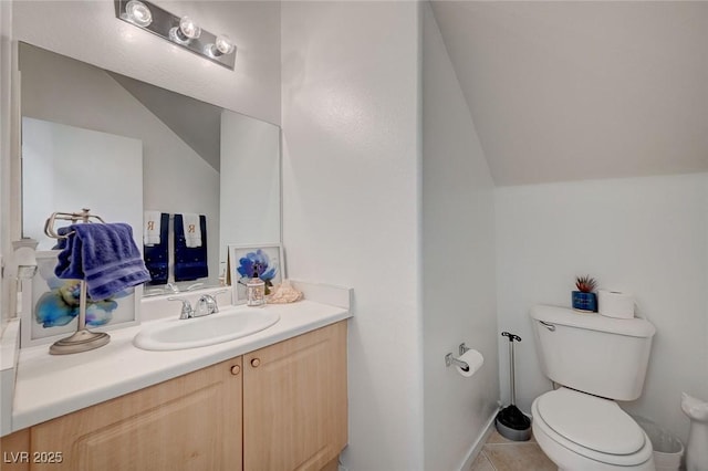 bathroom featuring lofted ceiling, toilet, vanity, and tile patterned floors