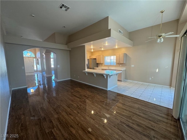 3136 Jane Austin Ave, North Las Vegas, NV 89031 - unfurnished living room with arched walkways, ornate columns, wood finished floors, a ceiling fan, and healthy amount of natural light