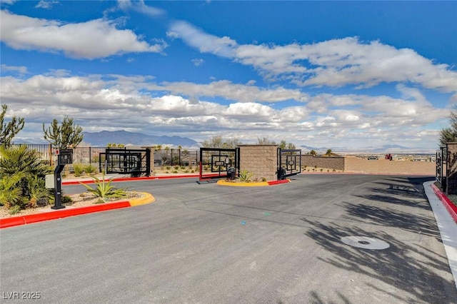 5236 Sunstone Mesa Dr, Las Vegas, NV 89166 - view of asphalt street featuring curbs, a gated entry, and a gate