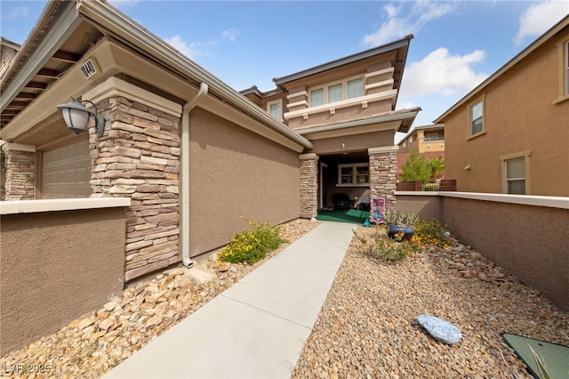 10440 Bay Ginger Ln, Las Vegas, NV 89135 - view of exterior entry with stone siding, stucco siding, fence, and a garage