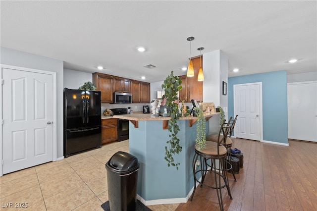 10440 Bay Ginger Ln, Las Vegas, NV 89135 - kitchen featuring freestanding refrigerator, stainless steel microwave, electric range oven, a kitchen breakfast bar, and light countertops