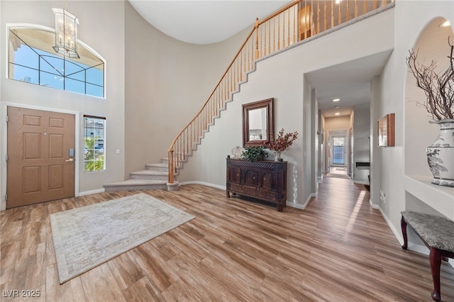6999 Stone Meadows Ave, Las Vegas, NV 89142 - entryway featuring a towering ceiling, wood finished floors, a chandelier, stairway, and baseboards