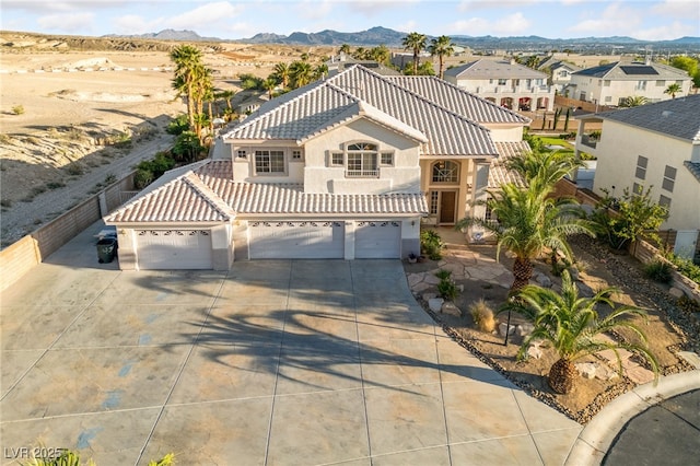 6999 Stone Meadows Ave, Las Vegas, NV 89142 - mediterranean / spanish home featuring stucco siding, a tile roof, a mountain view, an attached garage, and concrete driveway