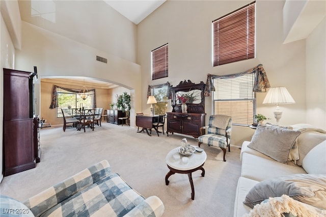 6999 Stone Meadows Ave, Las Vegas, NV 89142 - carpeted living area featuring arched walkways and a high ceiling