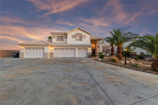 6999 Stone Meadows Ave, Las Vegas, NV 89142 - mediterranean / spanish home with stucco siding, driveway, a tiled roof, an attached garage, and a garage