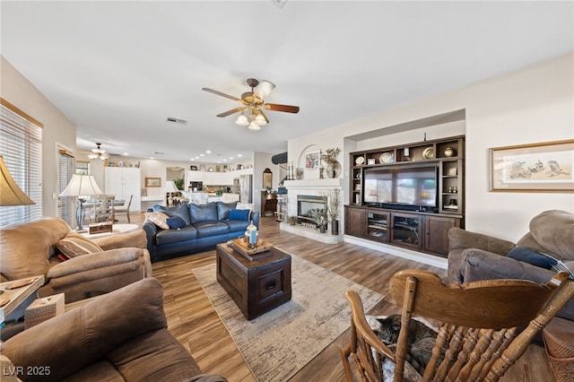 6999 Stone Meadows Ave, Las Vegas, NV 89142 - living room with ceiling fan, wood finished floors, a fireplace with raised hearth, and recessed lighting