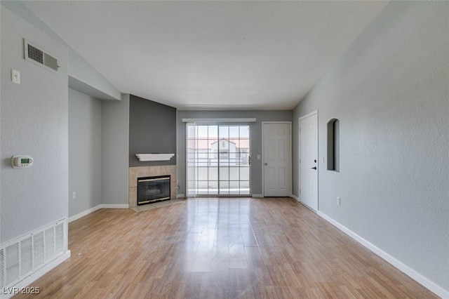 3318 N Decatur Blvd Unit 2110, Las Vegas, NV 89130 - unfurnished living room with light wood-type flooring, a fireplace, baseboards, and a textured wall