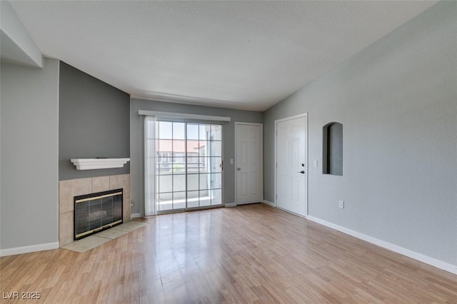 3318 N Decatur Blvd Unit 2110, Las Vegas, NV 89130 - unfurnished living room featuring wood finished floors, a tile fireplace, and baseboards