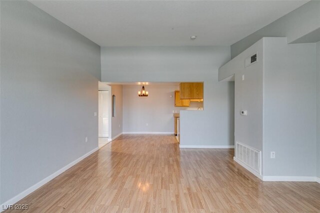 3318 N Decatur Blvd Unit 2110, Las Vegas, NV 89130 - unfurnished living room with a chandelier, light wood finished floors, and baseboards