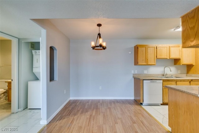 3318 N Decatur Blvd Unit 2110, Las Vegas, NV 89130 - kitchen with white dishwasher, a sink, estacked washer and dryer, and baseboards