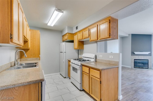 3318 N Decatur Blvd Unit 2110, Las Vegas, NV 89130 - kitchen with white appliances, a sink, light marble finish flooring, baseboards, and a tile fireplace