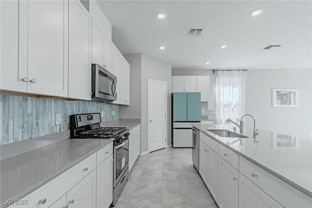 4589 Swimming Minnow Ave, Las Vegas, NV 89141 - kitchen with stainless steel appliances, a sink, light countertops, white cabinets, and recessed lighting