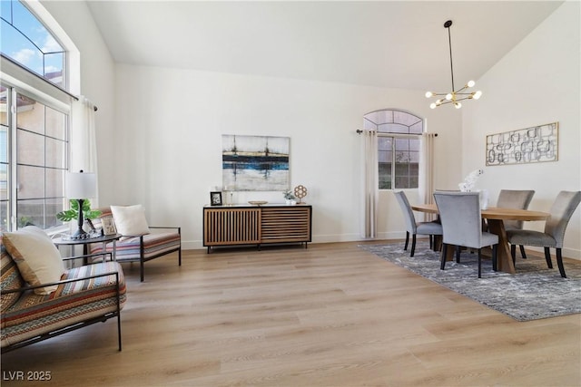 8714 Las Posas Ave, Las Vegas, NV 89147 - dining area with high vaulted ceiling, a chandelier, wood finished floors, and baseboards