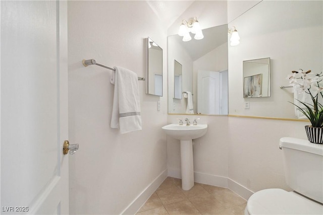 8714 Las Posas Ave, Las Vegas, NV 89147 - bathroom with toilet, tile patterned floors, baseboards, vaulted ceiling, and a sink