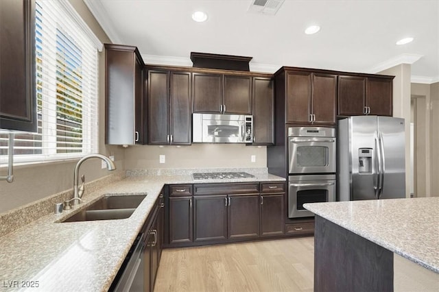 7428 Alamo Ranch Ave, Las Vegas, NV 89179 - kitchen with appliances with stainless steel finishes, a sink, ornamental molding, dark brown cabinets, and light wood-style flooring