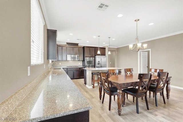 7428 Alamo Ranch Ave, Las Vegas, NV 89179 - dining area featuring light wood-style floors, crown molding, a chandelier, recessed lighting, and baseboards