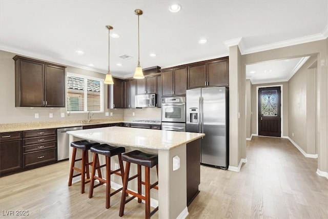 7428 Alamo Ranch Ave, Las Vegas, NV 89179 - kitchen featuring stainless steel appliances, a sink, dark brown cabinets, ornamental molding, and light wood-style floors