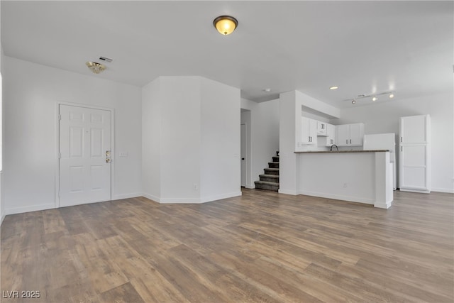 4149 Dignified Ct, North Las Vegas, NV 89032 - unfurnished living room with wood finished floors, stairs, and baseboards
