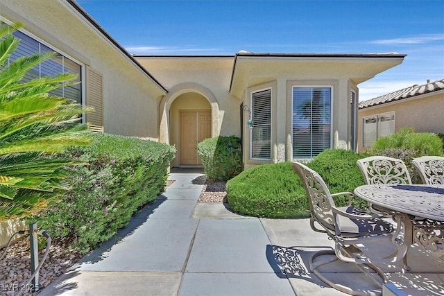 5068 Rivedro St, Las Vegas, NV 89135 - entrance to property with stucco siding, a patio, and outdoor dining space