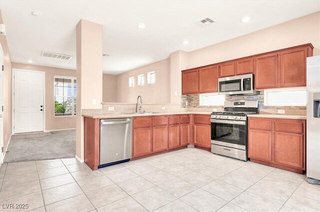 10230 Viterbo St, Las Vegas, NV 89183 - kitchen with appliances with stainless steel finishes, a sink, brown cabinets, tasteful backsplash, and recessed lighting