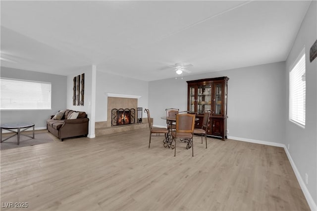 721 Carpenter Dr, Las Vegas, NV 89107 - dining room featuring a lit fireplace, light wood-type flooring, ceiling fan, and baseboards