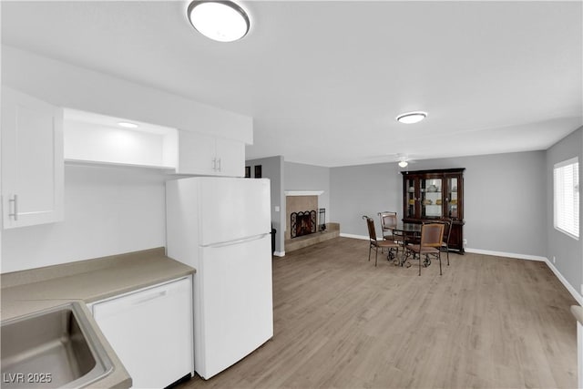 721 Carpenter Dr, Las Vegas, NV 89107 - kitchen with freestanding refrigerator, white cabinetry, and light wood-style flooring