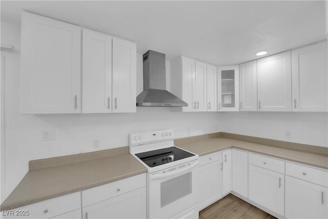 721 Carpenter Dr, Las Vegas, NV 89107 - kitchen with wall chimney exhaust hood, white electric range oven, white cabinetry, glass insert cabinets, and light countertops