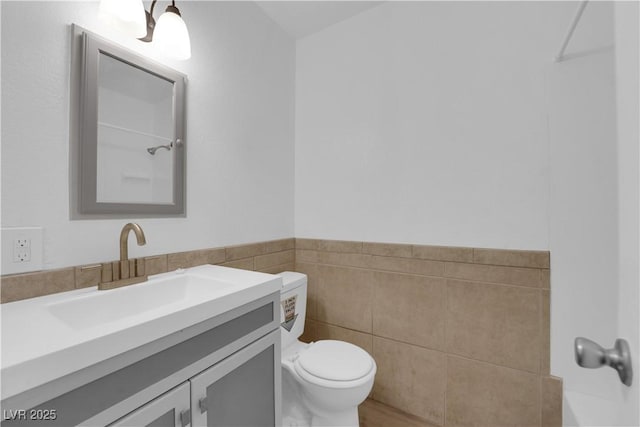 721 Carpenter Dr, Las Vegas, NV 89107 - full bathroom featuring toilet, vanity, tile walls, and a wainscoted wall