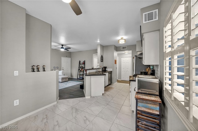 8501 W University Ave Unit 1083, Las Vegas, NV 89147 - kitchen with a ceiling fan, dark countertops, baseboards, open floor plan, and white cabinets