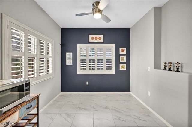 8501 W University Ave Unit 1083, Las Vegas, NV 89147 - unfurnished room featuring marble look tiles, a ceiling fan, plenty of natural light, and baseboards