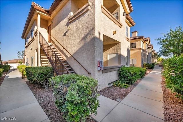 8501 W University Ave Unit 1083, Las Vegas, NV 89147 - view of property exterior with stucco siding, stairs, and a tile roof