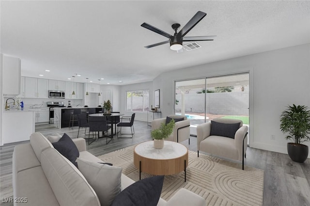 9541 Summersweet Ct, Las Vegas, NV 89123 - living room with light wood-type flooring, ceiling fan, recessed lighting, and baseboards