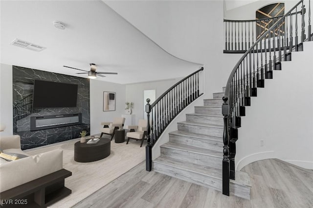 9541 Summersweet Ct, Las Vegas, NV 89123 - staircase featuring a high end fireplace, wood finished floors, and ceiling fan