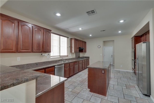 5912 Kit Cove Ct, Las Vegas, NV 89131 - kitchen featuring stainless steel appliances, a center island, stone counters, recessed lighting, and light stone finish flooring