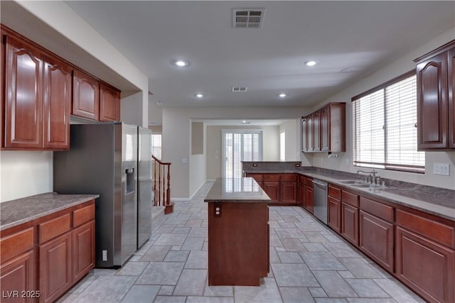 5912 Kit Cove Ct, Las Vegas, NV 89131 - kitchen with stainless steel appliances, a sink, a center island, light stone finish floors, and plenty of natural light