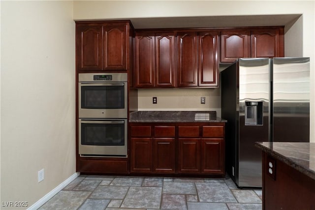 5912 Kit Cove Ct, Las Vegas, NV 89131 - kitchen featuring appliances with stainless steel finishes, dark stone counters, light stone finish flooring, dark brown cabinets, and baseboards
