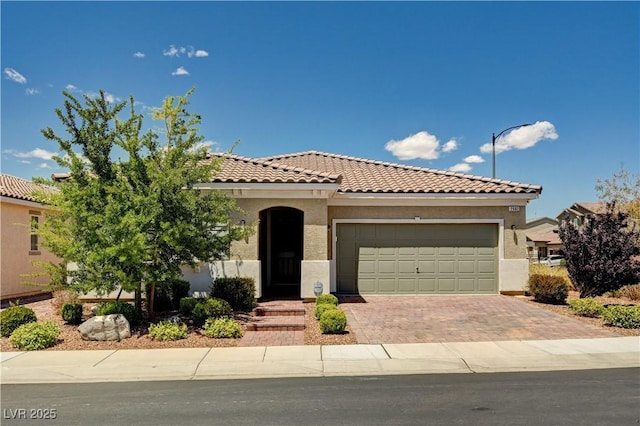 2902 Ventana Ridge Ave, Henderson, NV 89044 - mediterranean / spanish house with an attached garage, a tile roof, decorative driveway, and stucco siding