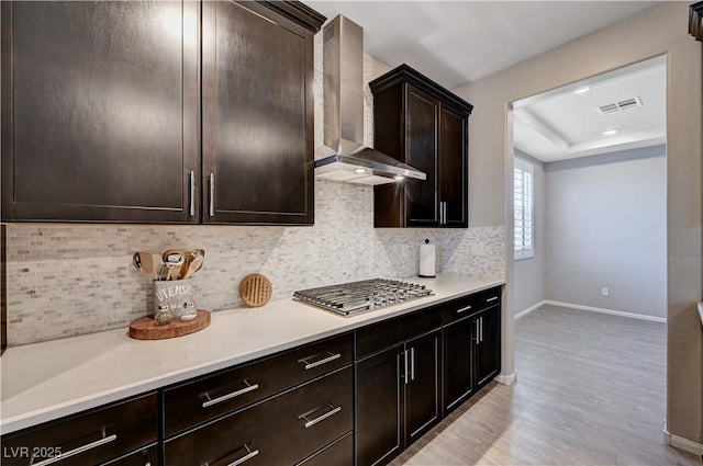 2902 Ventana Ridge Ave, Henderson, NV 89044 - kitchen with wall chimney range hood, baseboards, stainless steel gas stovetop, light wood finished floors, and light countertops