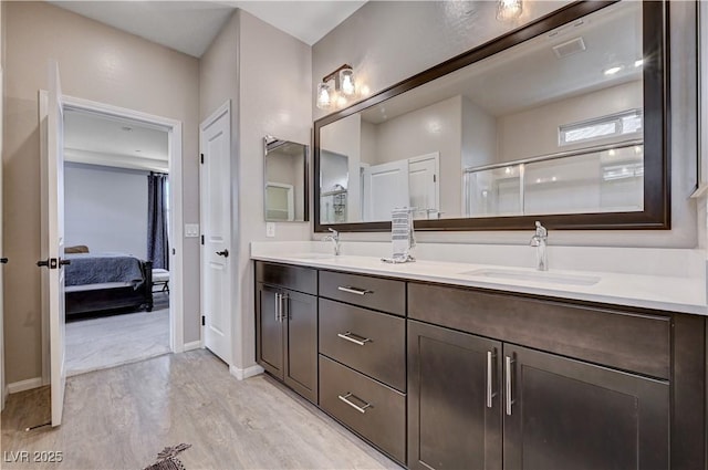 2902 Ventana Ridge Ave, Henderson, NV 89044 - full bathroom with wood finished floors, double vanity, baseboards, connected bathroom, and a shower with door