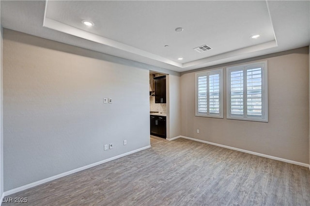 2902 Ventana Ridge Ave, Henderson, NV 89044 - spare room with a tray ceiling, light wood-style flooring, baseboards, and recessed lighting