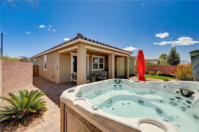 2902 Ventana Ridge Ave, Henderson, NV 89044 - rear view of house featuring a hot tub, stucco siding, a fenced backyard, and a tiled roof