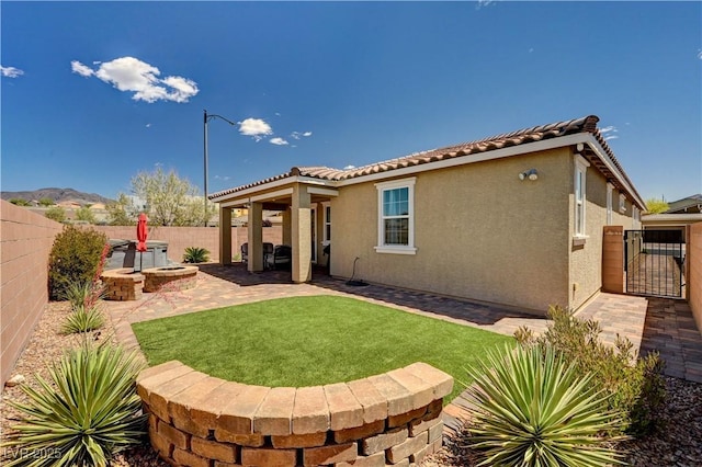 2902 Ventana Ridge Ave, Henderson, NV 89044 - rear view of property featuring a fenced backyard, stucco siding, a patio, a tiled roof, and a gate