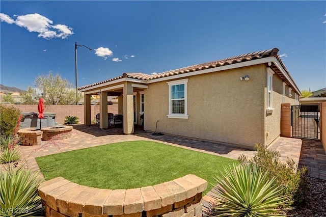 2902 Ventana Ridge Ave, Henderson, NV 89044 - back of house with a patio, stucco siding, a tiled roof, and a gate