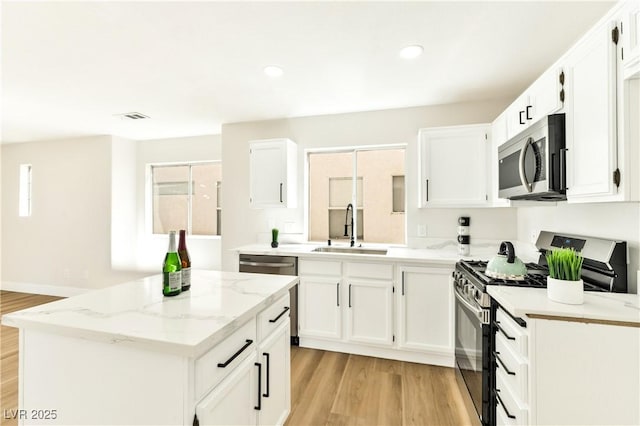 1724 Navajo Lake Way, Las Vegas, NV 89128 - kitchen featuring appliances with stainless steel finishes, a sink, light wood finished floors, a kitchen island, and recessed lighting