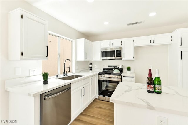 1724 Navajo Lake Way, Las Vegas, NV 89128 - kitchen featuring stainless steel appliances, a sink, light stone countertops, white cabinetry, and recessed lighting