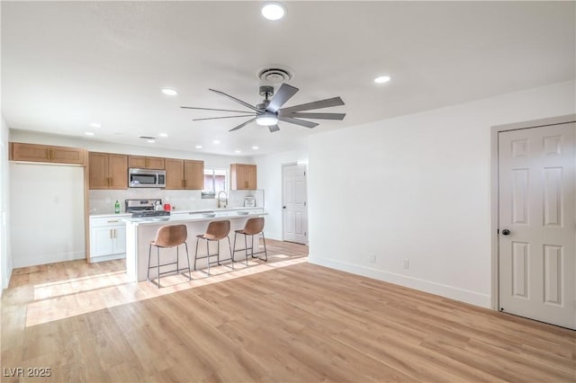 5239 Elgin Cir, Las Vegas, NV 89122 - kitchen featuring appliances with stainless steel finishes, light countertops, ceiling fan, a breakfast bar area, and recessed lighting